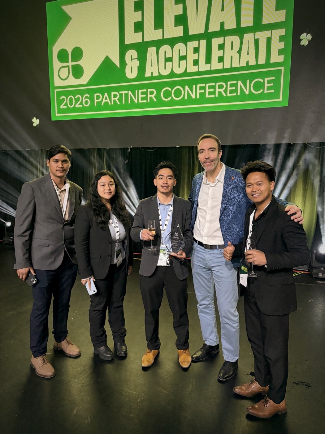 The GT Legacy team on stage at the 2026 Clover partner conference holding their award